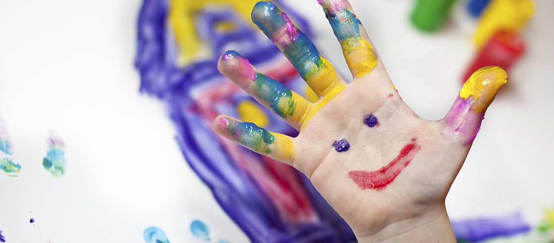 Mano pintada con una carita sonriente